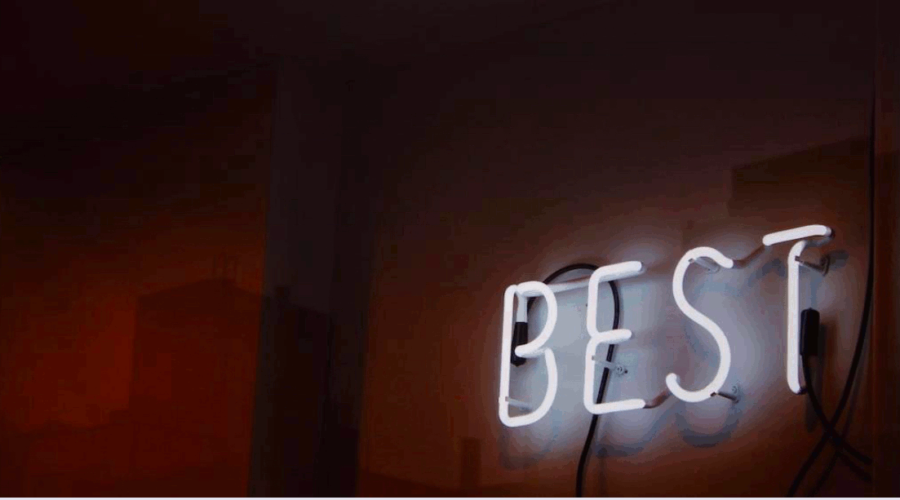 Dark wall with a neon sign glowing white that says "BEST". This is used in a post on how Stoicism helps you on being your best. It is on www.becomingstoic.net in a post called "How To Be you Best".